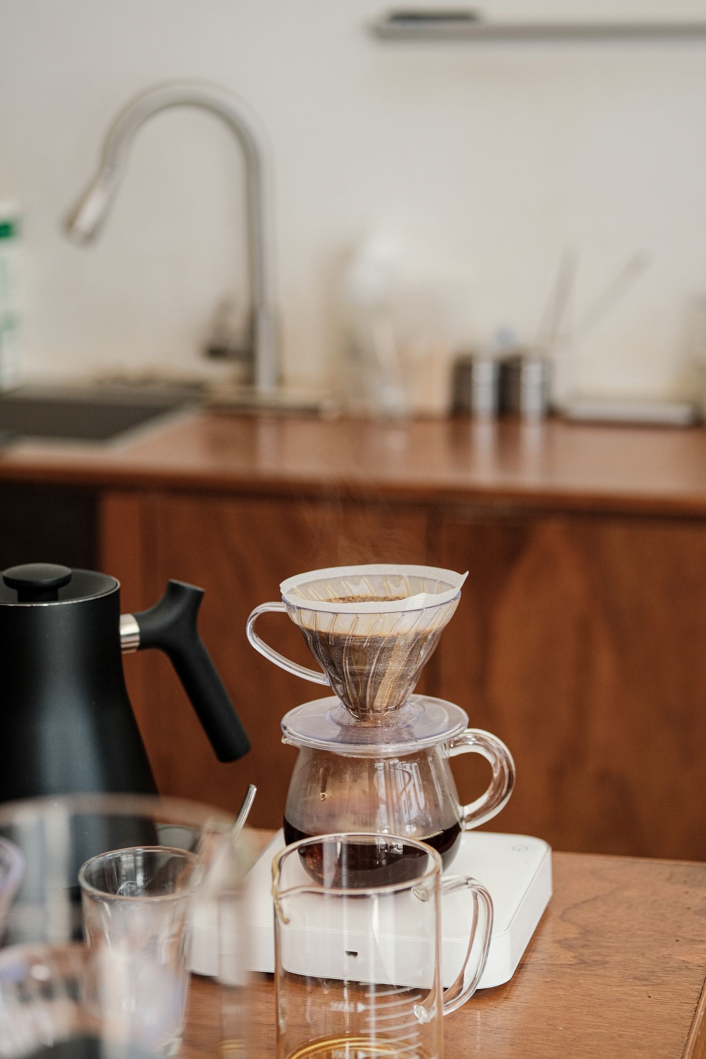 A pour-over coffee dripper and kettle on a quiet kitchen counter